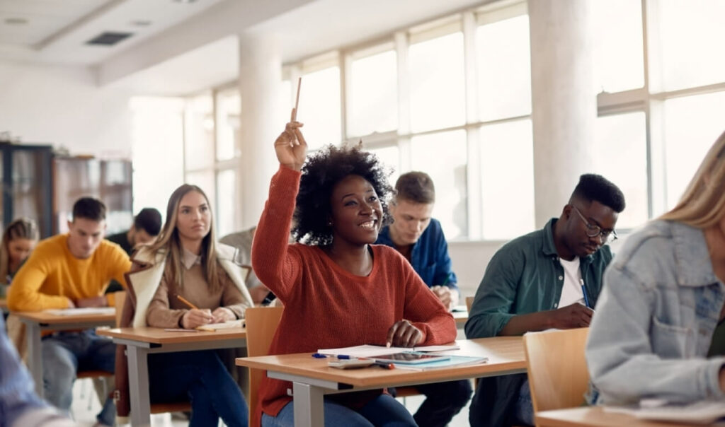 Leerlingen in klaslokaal die vragen stellen over de auto theorie.